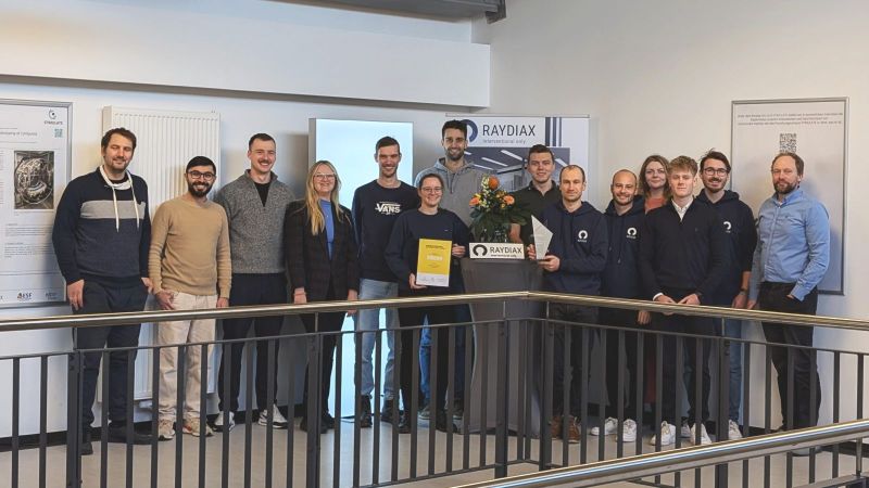 Die Gruppe postiert auf einer Galerie vor Posterwänden
