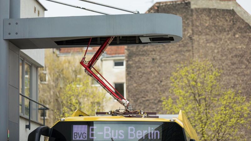 Ein Pantograph-System lädt einen Bus über einen beweglichen Stromabnehmer. Zu sehen ist nur der Stromabnehmer und ein Teil des Fahrzeugdaches.