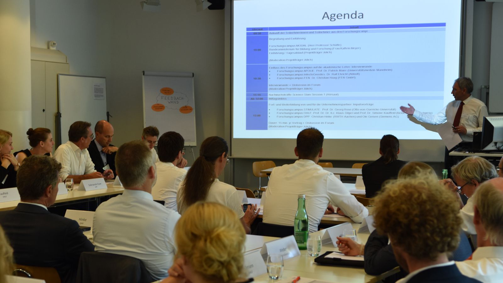 Publikum von hinten mit Blick auf die Präsentation