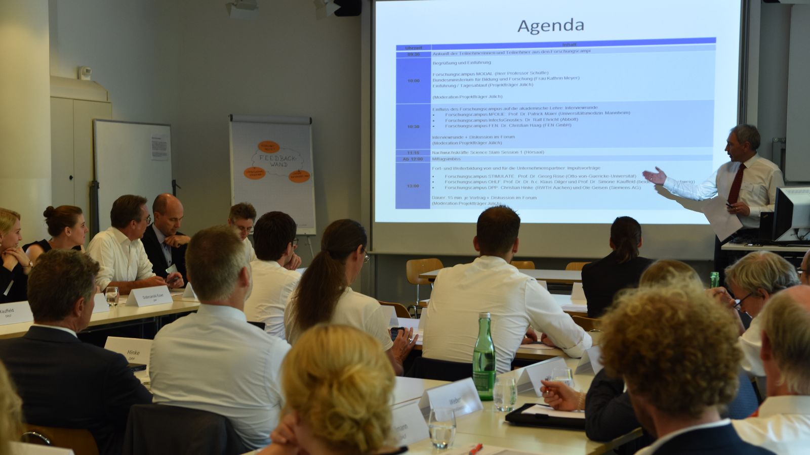 Publikum von hinten mit Blick auf die Präsentation